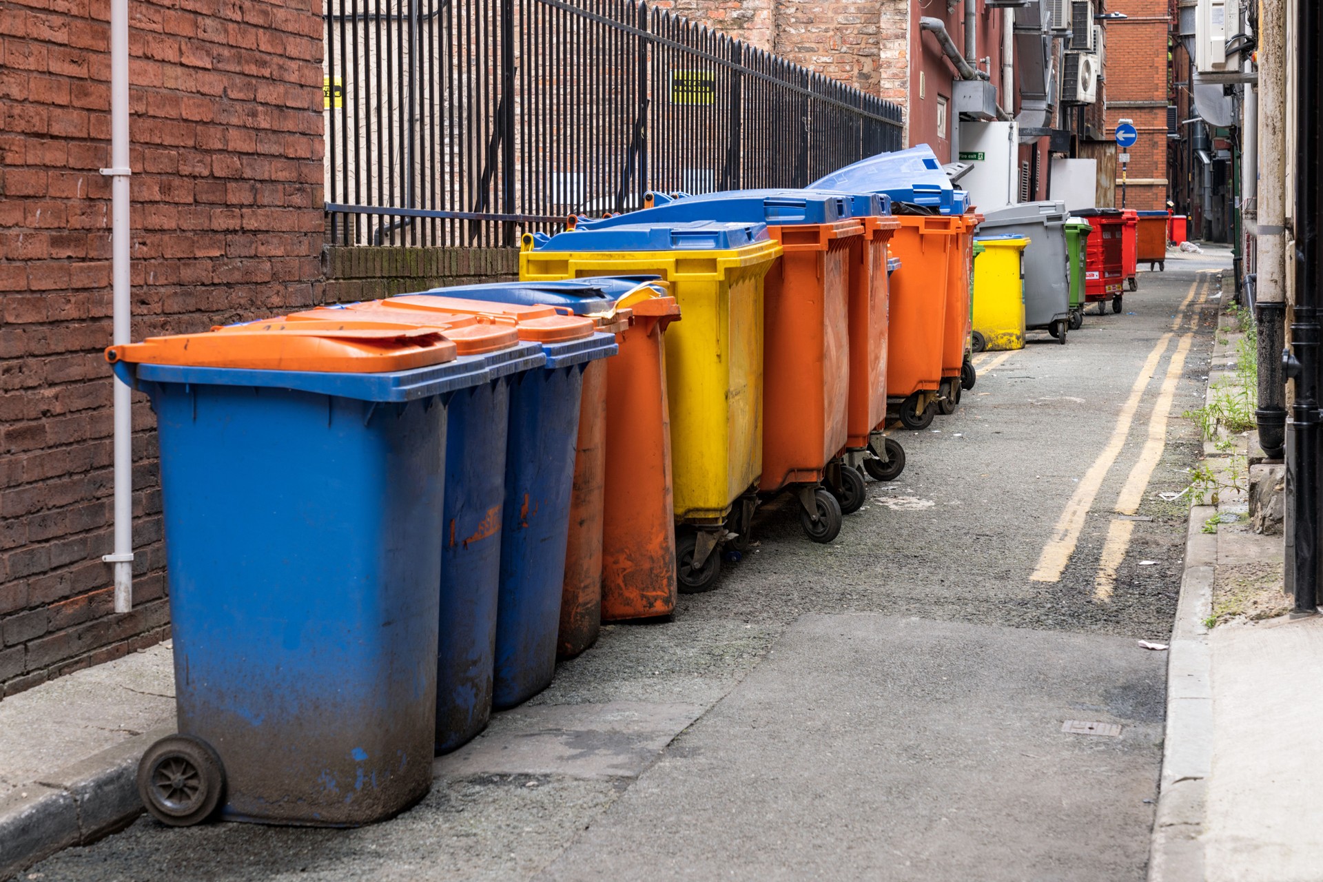 Long row of industrial bins in city alley